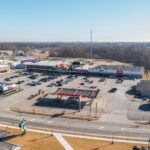 Drone view of Rushville Plaza with shopping strip, Hardees, and Kroger gas.