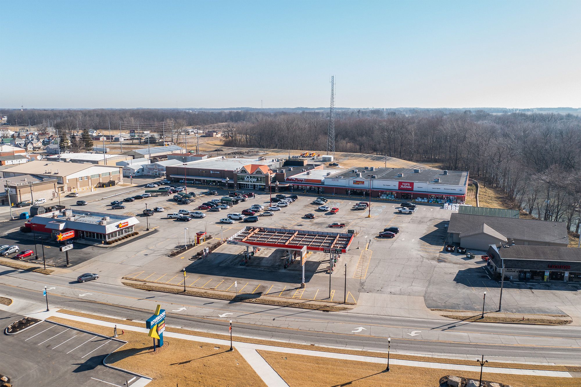 Drone view of Rushville Plaza with shopping strip, Hardees, and Kroger gas.