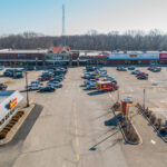 Drone view of Rushville Plaza storefronts and parking with Hardees in the foreground.