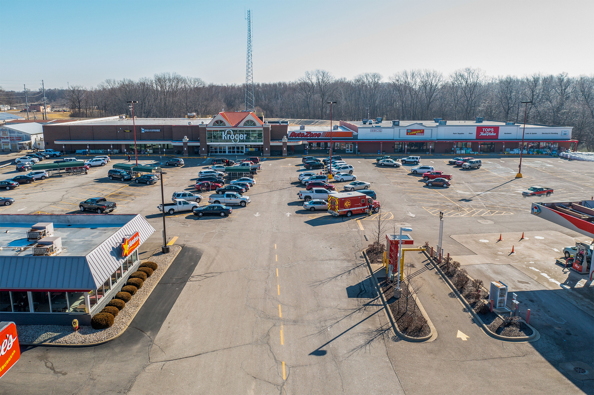 Drone view of Rushville Plaza storefronts and parking with Hardees in the foreground.
