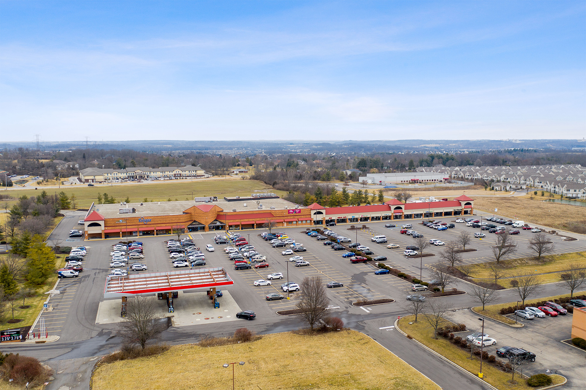 Drone view of Shoppes of Mason storefronts and Kroger gas station.