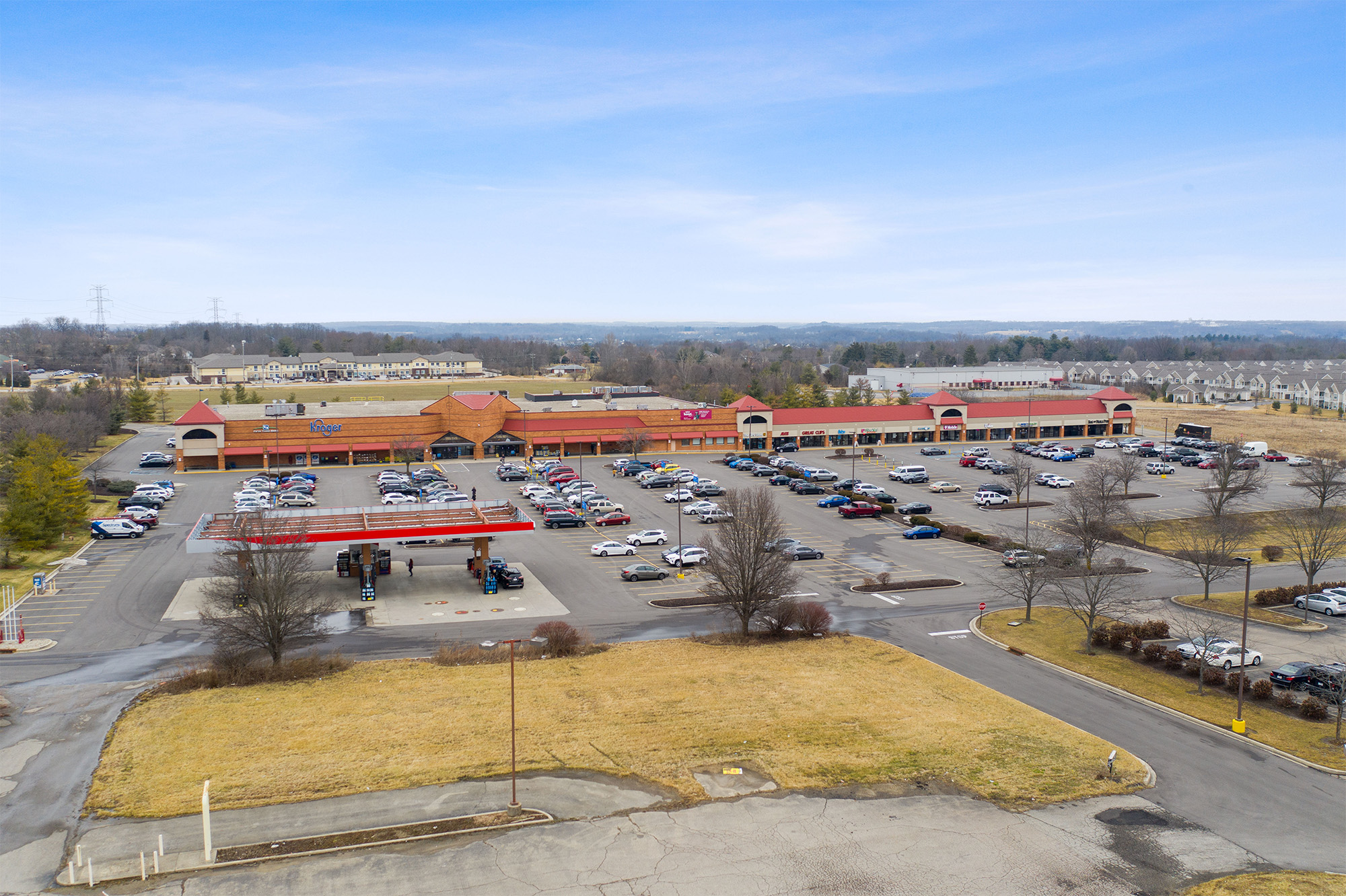 Drone view of Shoppes of Mason storefronts and Kroger gas station.