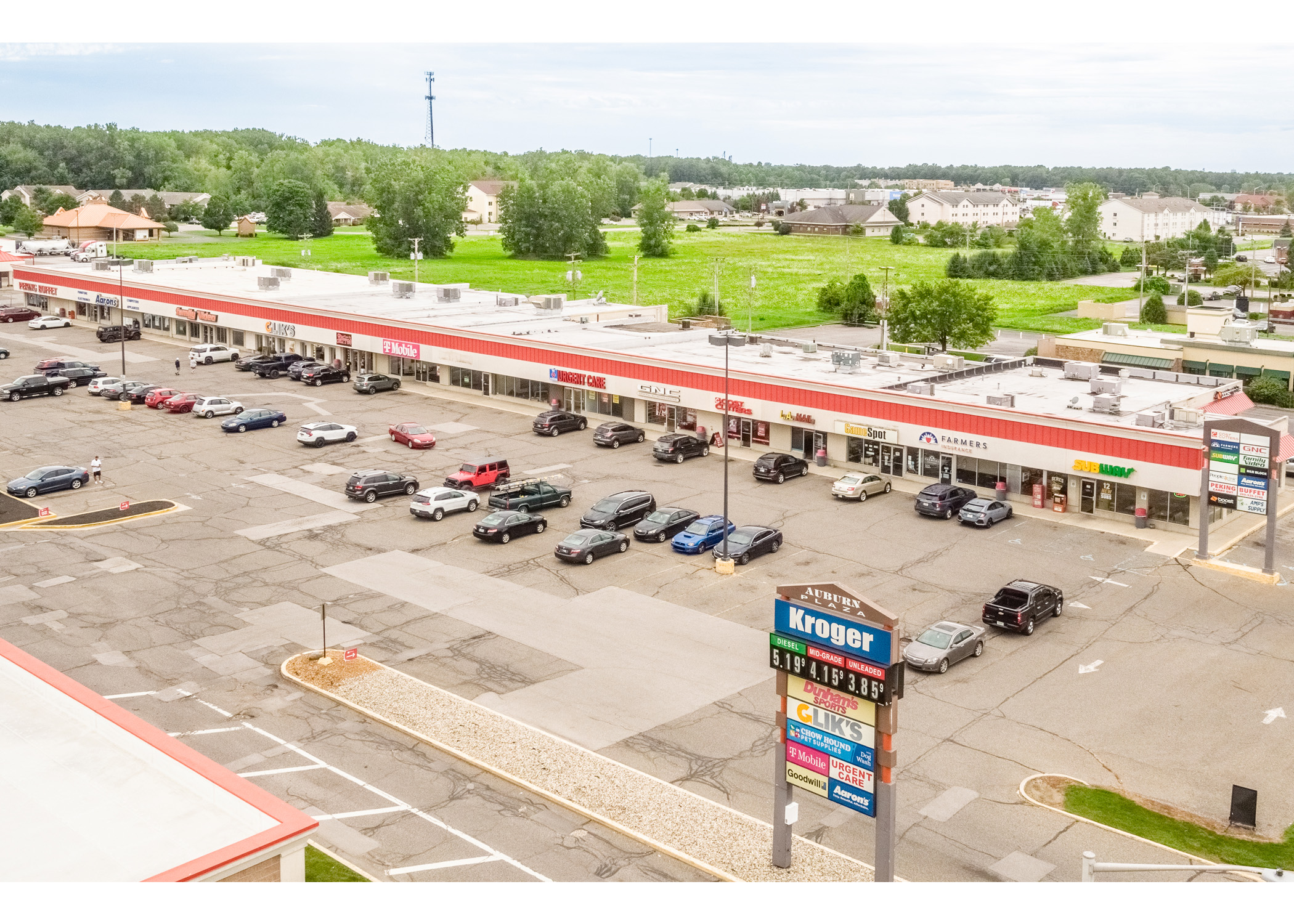 Auburn Plaza, Peking Buffet, Aaron's, Family Video, Clik's, Classic City Tattoo, T-Mobile, Urgent Care, GNC, Cost Cutters, LA Nail, Game Spot, Farmers Insurance, Subway, tenant signs and parking lot aerial view.