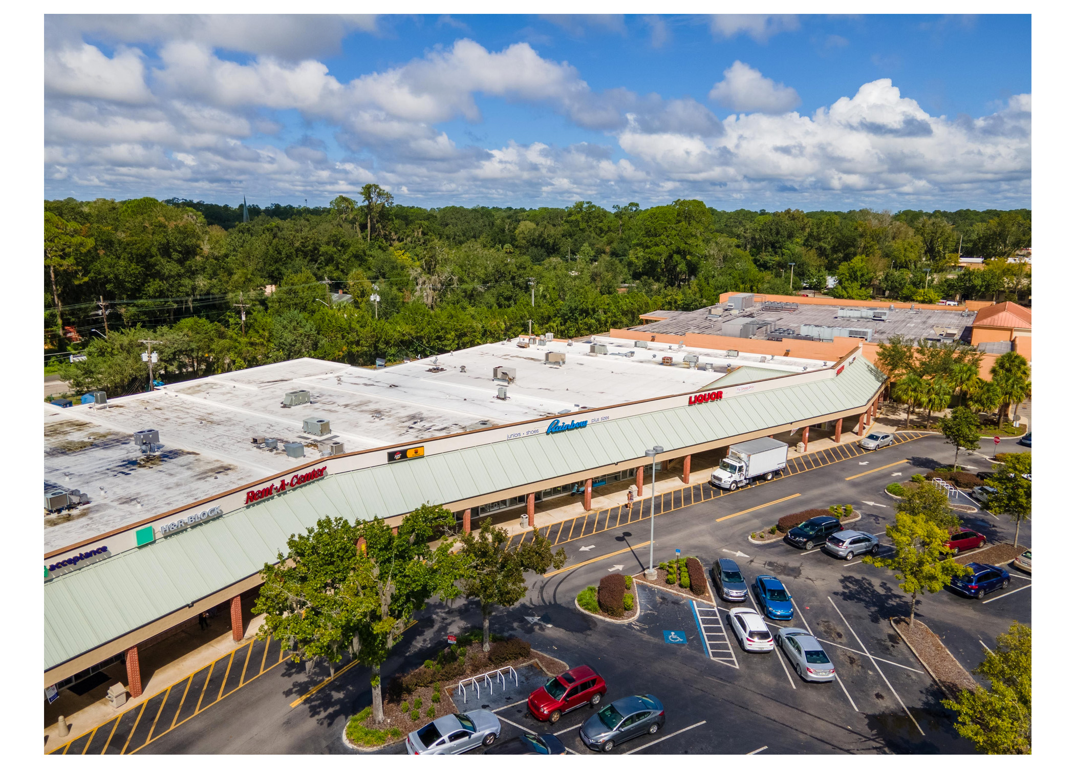 Gainesville Shopping Center, H&R Block, Rent A Center, Pizza Hut, Rainbow, Liquor and parking lot aerial view.
