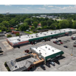 Plymouth Plaza Pizza Hut, Auto Zone, ASine, Dental Center, Nail Fever, UPS Store, Smith Farm Stores, Ace Hardware, Pizza Hut, Dragon Express and Laundry Mat Dry Cleaners parking lot, aerial view.