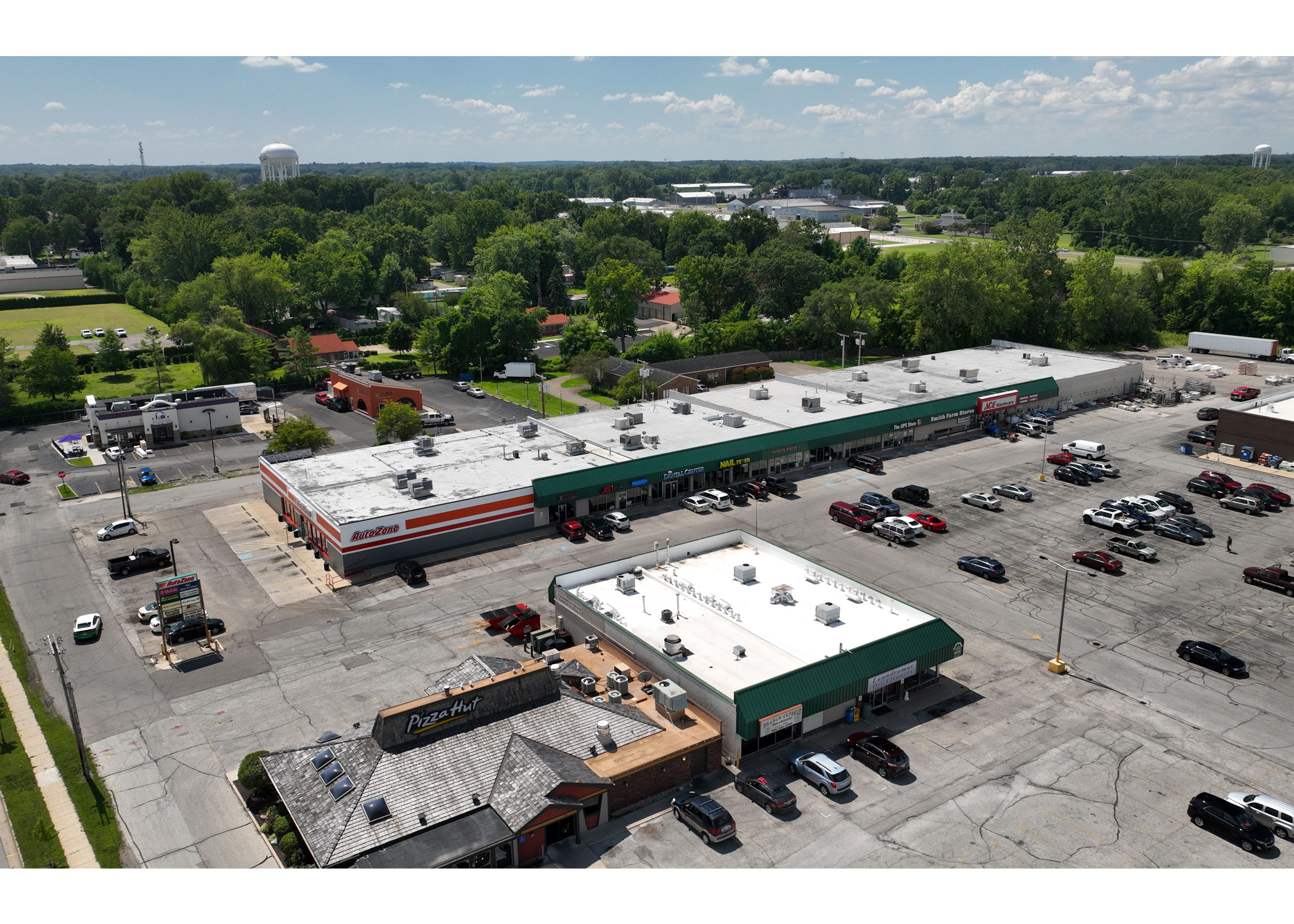 Plymouth Plaza Pizza Hut, Auto Zone, ASine, Dental Center, Nail Fever, UPS Store, Smith Farm Stores, Ace Hardware, Pizza Hut, Dragon Express and Laundry Mat Dry Cleaners parking lot, aerial view.